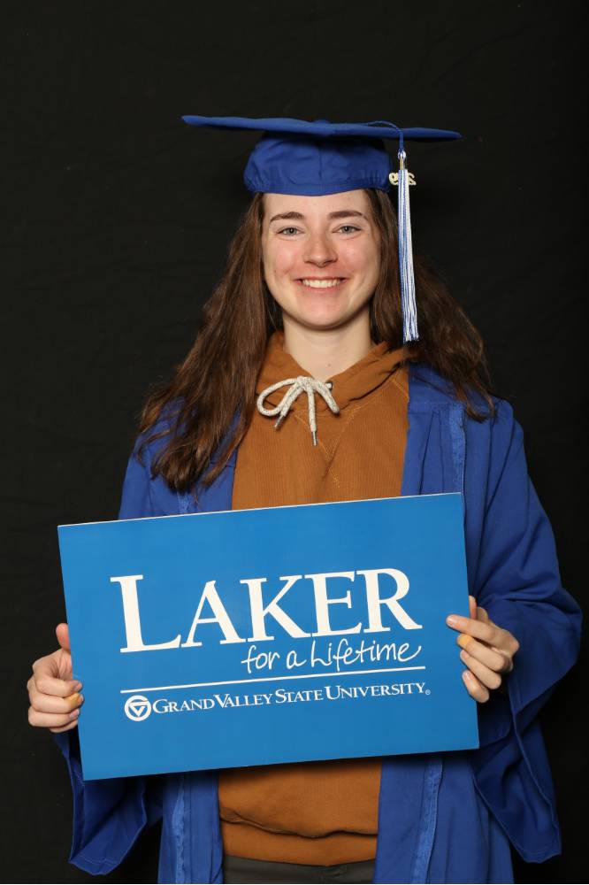graduate holding laker for a lifetime sign